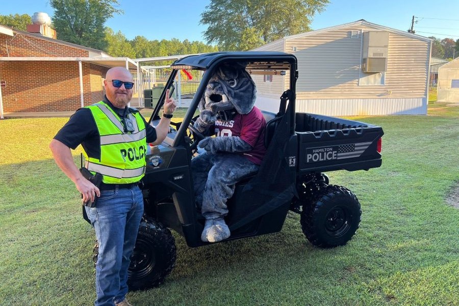 Hamilton police resource officer with the Aggies mascot